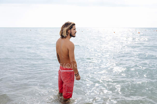 Uomo in piedi in mare — Foto stock