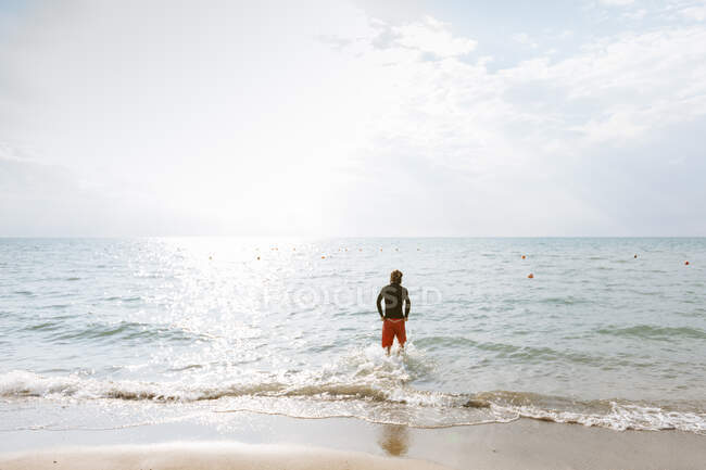 Mann steht am Rande des Meeres — Stockfoto