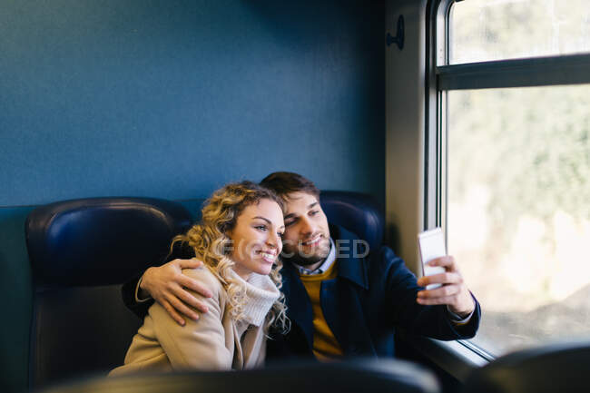 Пара делает селфи внутри поезда — стоковое фото