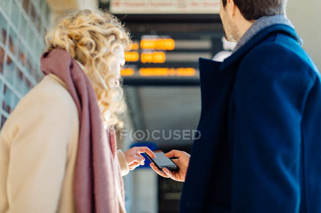 Casal verificando smartphone na estação de trem, Firenze, Toscana, Itália — Fotografia de Stock