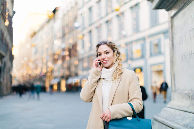 Mujer usando smartphone en piazza, Firenze, Toscana, Italia - foto de stock