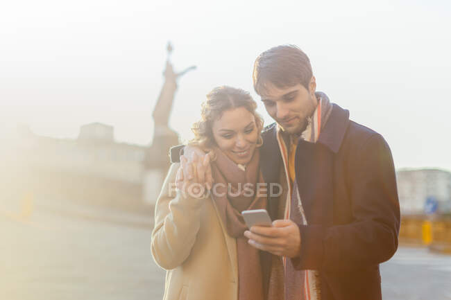 Пара с помощью смартфона на улице, Флоренция, Тоскана, Италия — стоковое фото