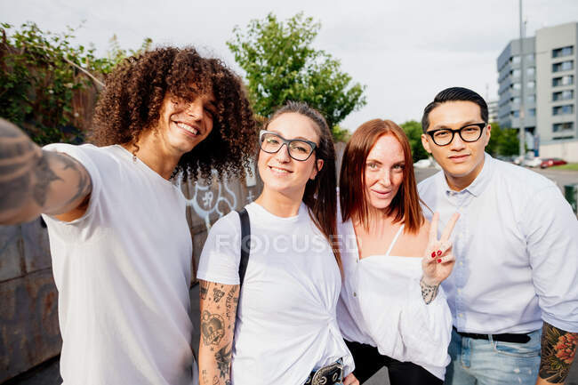 Grupo de amigos de raça mista saindo juntos na cidade, tirando selfie com celular. — Fotografia de Stock