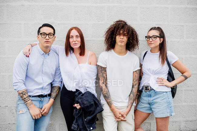Mixed race group of friends hanging out together in town. — Stock Photo