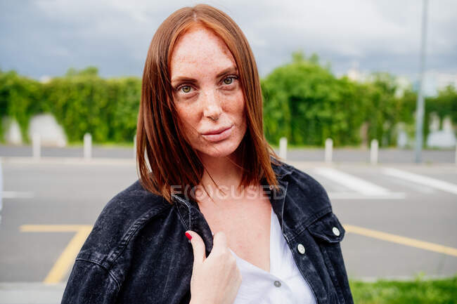 Porträt einer Frau mit langen roten Haaren, die in die Kamera blickt. — Stockfoto