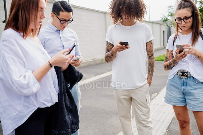 Grupo mixto de amigos pasando el rato juntos en la ciudad. - foto de stock