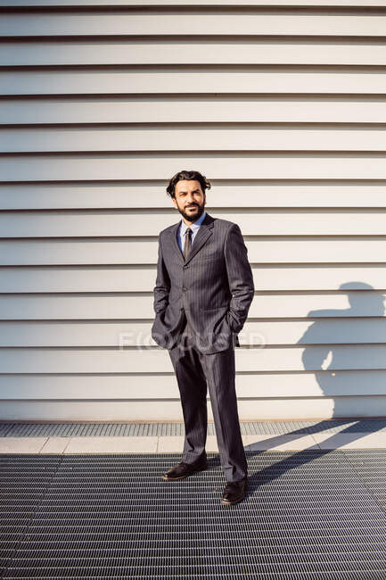 Porträt eines bärtigen Geschäftsmannes im dunklen Anzug, der in die Kamera blickt. — Stockfoto