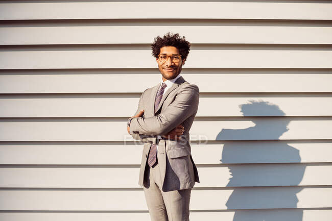 Porträt eines Geschäftsmannes mit Brille und grauem Anzug, der in die Kamera lächelt. — Stockfoto