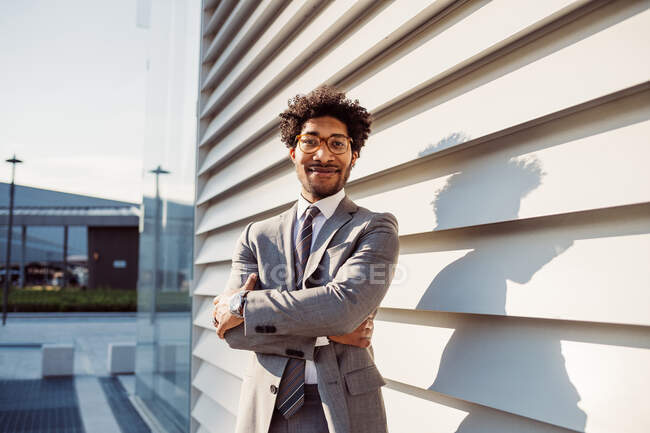 Portrait of businessman wearing glasses and grey suit, smiling at camera. — Stock Photo