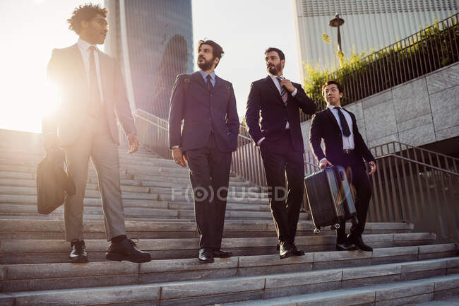 Grupo mixto de empresarios pasando el rato juntos en la ciudad. - foto de stock