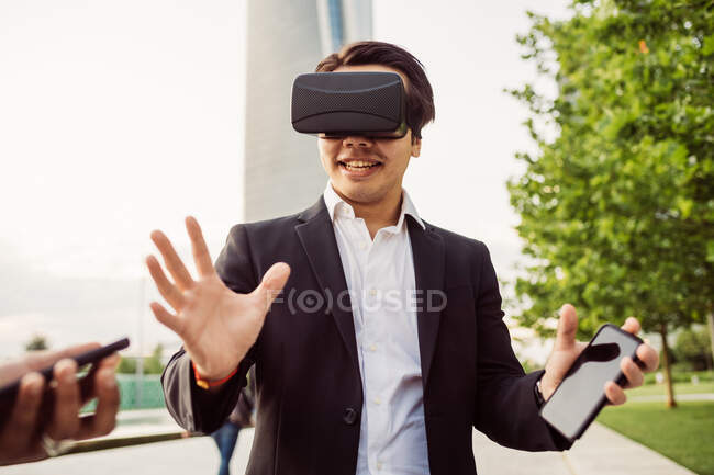 Retrato de empresário asiático vestindo fone de ouvido VR. — Fotografia de Stock