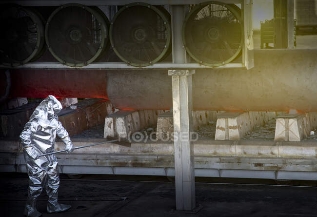 Man wearing silver heat-protective suit working in a steel factory. — Stock Photo