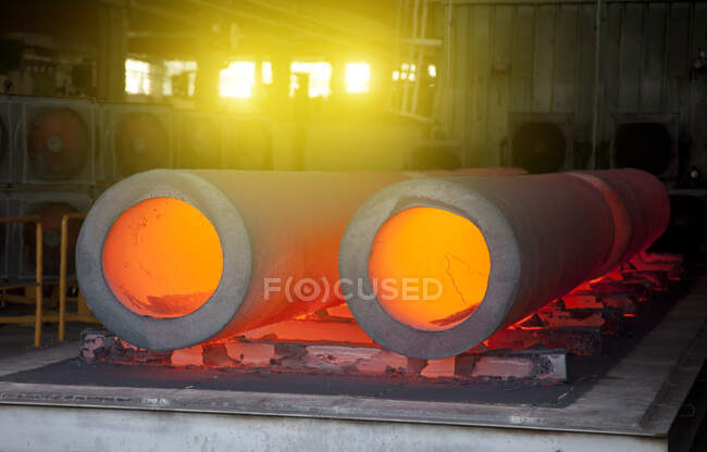 Primer plano de tubos calientes brillantes en una fábrica de acero. - foto de stock