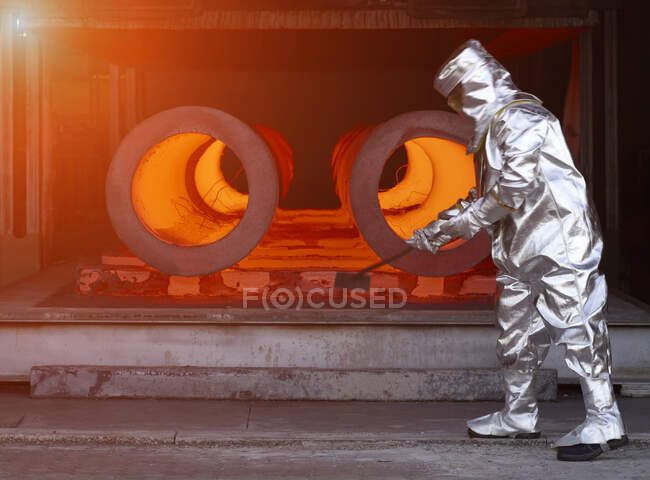 Homem usando terno de proteção térmica prata trabalhando em uma fábrica de aço. — Fotografia de Stock