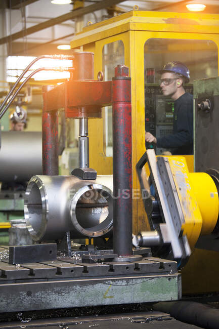 Mann arbeitet an einer Maschine in einer Stahlfabrik. — Stockfoto