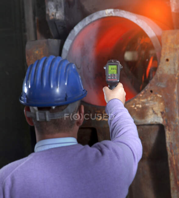 Man working in a steel factory, inspecting steel tube. — Stock Photo