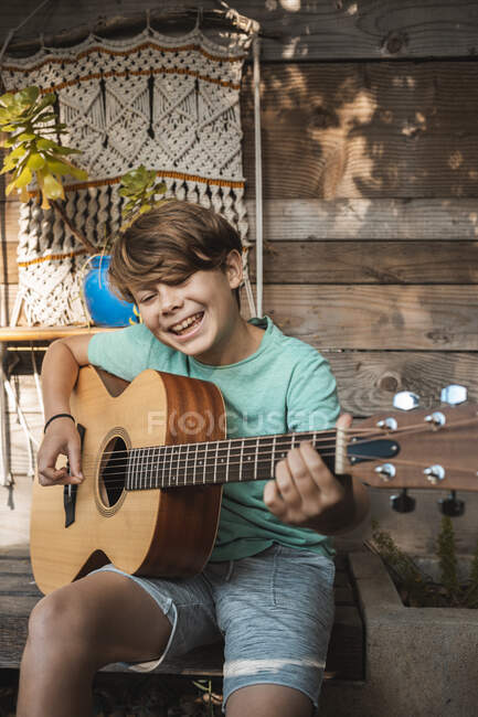 Portrait of brown haired boy playing guitar. — Stock Photo