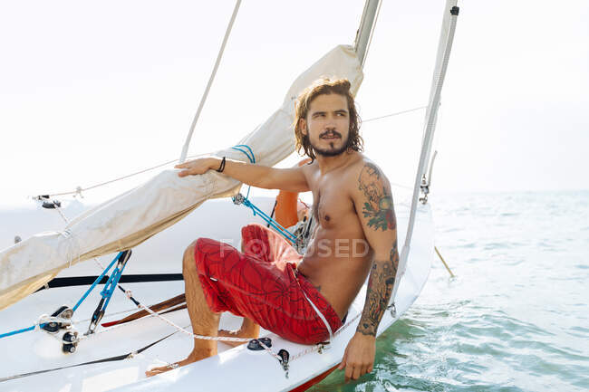 Mann auf Segelboot im flachen Wasser — Stockfoto