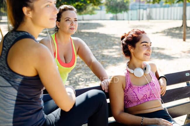 Amigos tomando un descanso del ejercicio en el parque, vista de cerca - foto de stock