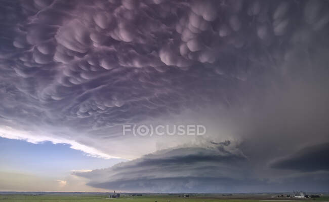 Nuvem intensa de mamíferos no flanco frontal vista sobre uma tempestade de tornado ao entardecer — Fotografia de Stock