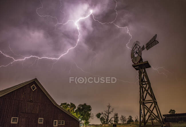 La foudre rampante de l'enclume illumine une vieille grange pendant un orage — Photo de stock