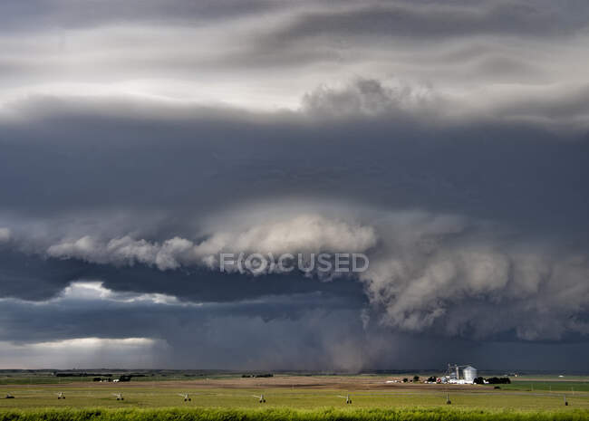 Nuvens de parede escuras e claras giram abaixo de uma super-célula tornado chutando poeira para a base ascendente. — Fotografia de Stock
