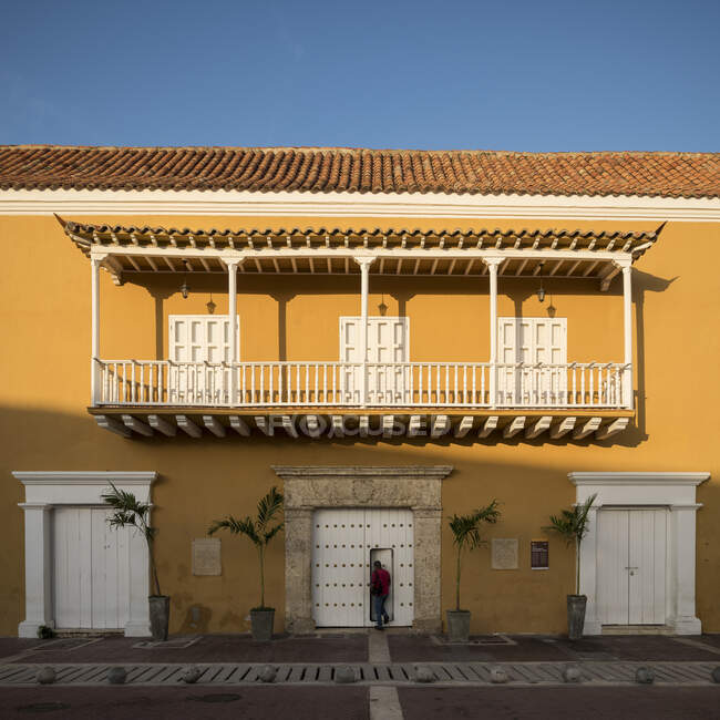 Façade du bâtiment historique dans la vieille ville, murs peints, balcon et fenêtres et portes à volets. — Photo de stock