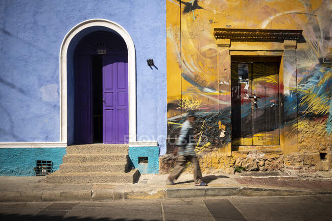 Frentes coloridos de la casa, puerta púrpura, y urals pintados en casa vieja en una terraza en la ciudad vieja - foto de stock
