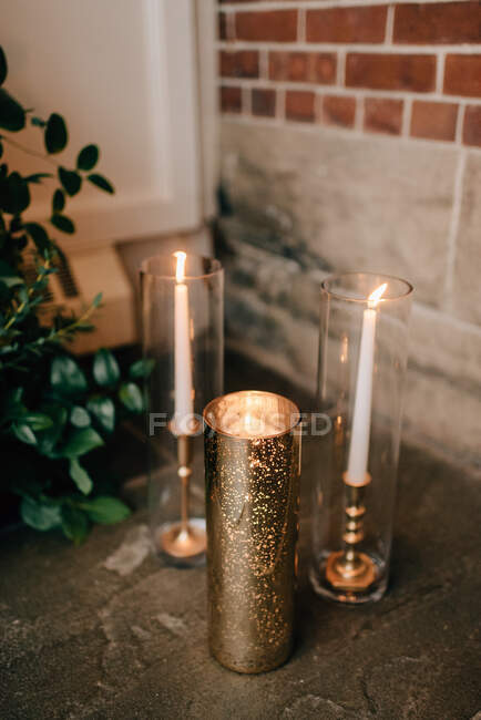 Close up di decorazioni nuziali, candele bianche in vetro e portacandele in oro. — Foto stock