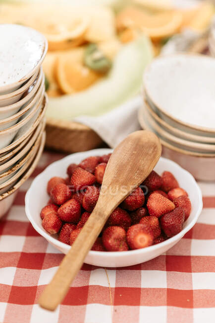 Hohe Nahaufnahme von Holzlöffel auf Schüssel mit Erdbeeren. — Stockfoto