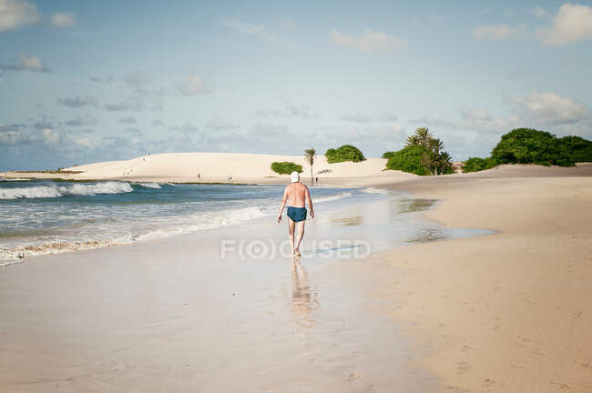 Человек прогуливается по тропическому пляжу — стоковое фото