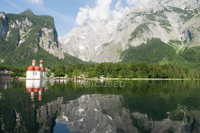 Montañas reflejadas en lago aún rural - foto de stock