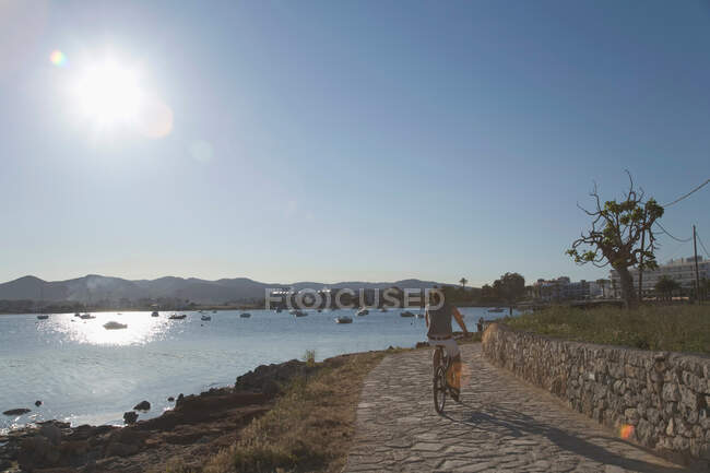 Man riding bicycle along waterfront — Stock Photo