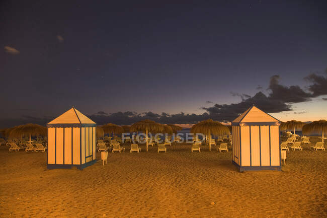 Cabanas e cadeiras de gramado na praia tropical — Fotografia de Stock