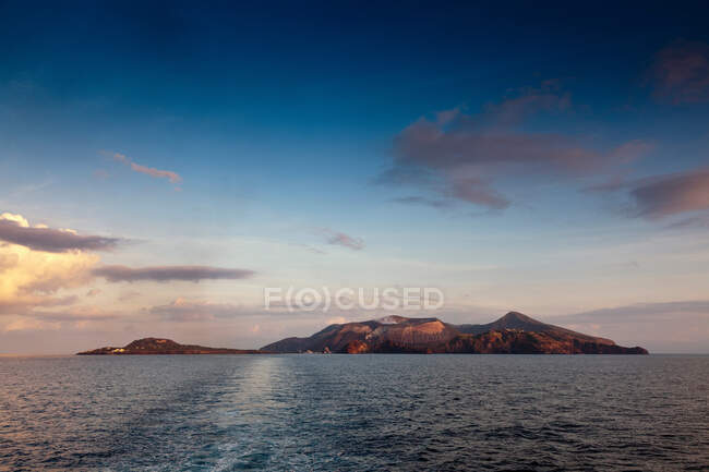 Montagne e oceano sotto il cielo blu — Foto stock