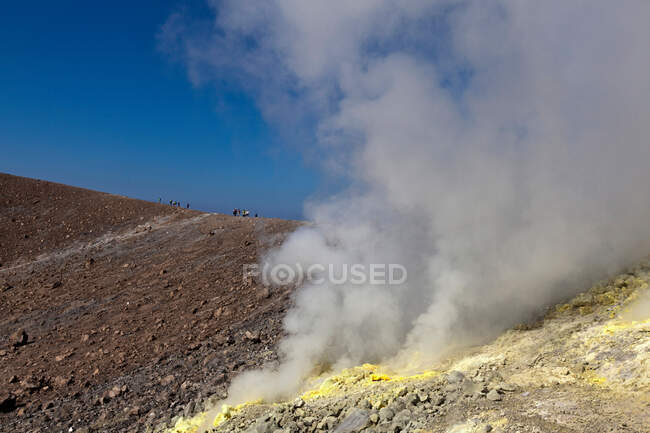 Steam from hot spring on rocky hillside — Stock Photo