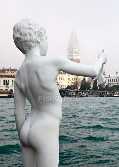 Niño con estatua de rana, Venecia, Italia - foto de stock