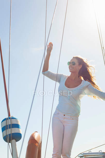 Женщина на яхте с поднятой рукой — стоковое фото