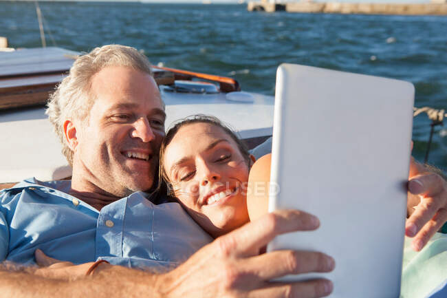 Пара на яхте с цифровым планшетом — стоковое фото