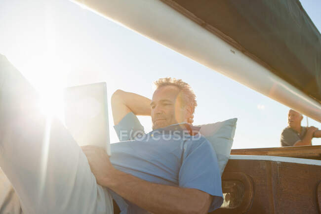 Чоловік на яхті з цифровим планшетом — стокове фото