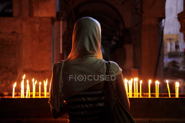 Woman in front of candles at Church of the Holy Sepulchre, Jerusalem, Israel — Stock Photo