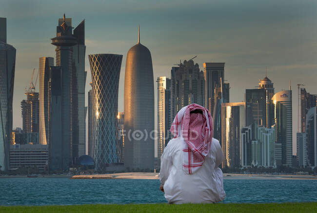 Homme regardant les gratte-ciel futuristes du centre-ville de Doha, Qatar — Photo de stock