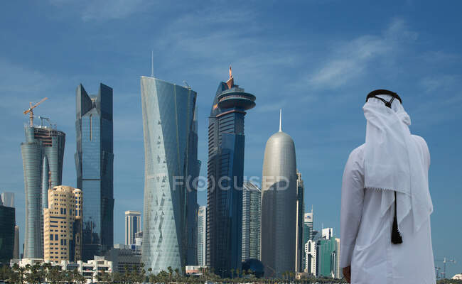 Mann blickt auf futuristische Wolkenkratzer in der Innenstadt von Doha, Katar — Stockfoto