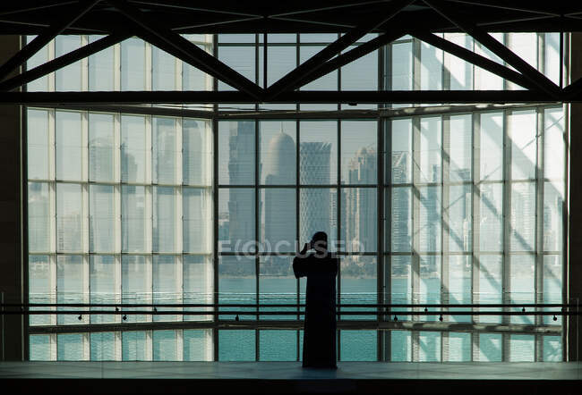 Mujer tomando fotos del horizonte de Doha del Museo de Arte Islámico de Doha, Qatar - foto de stock