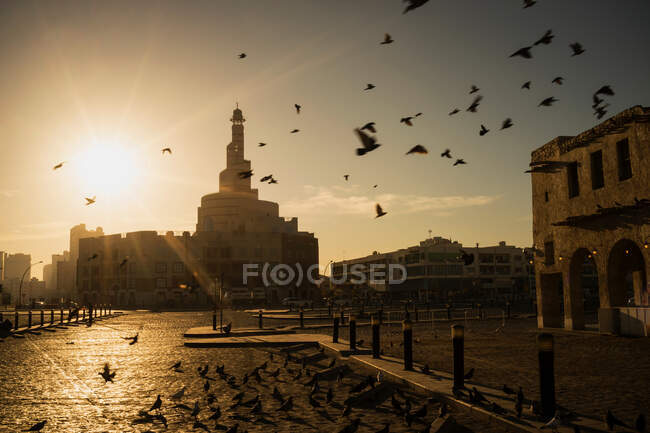 Salida del sol sobre el minarete de la mezquita de Qatar / Centro Cultural Islámico (Fanar), Doha, Qatar - foto de stock