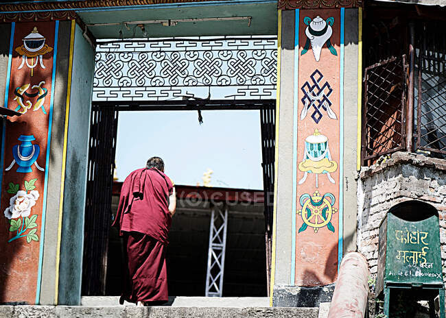 Monje que entra en el templo, Swayambhunath, Katmandú, Nepal - foto de stock