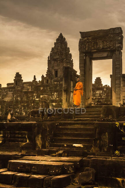 Monje, ruinas del templo de Bakong (parte del grupo de Roluos de templos hindúes pre-angkorianos), Bakong, Camboya - foto de stock