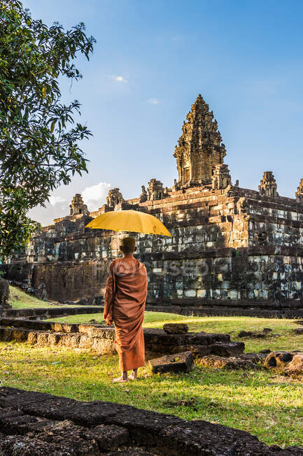 Monge com guarda-chuva, ruínas do Templo Bakong (parte do Grupo Roluos de templos hindus pré-Angkorianos), Bakong, Camboja — Fotografia de Stock