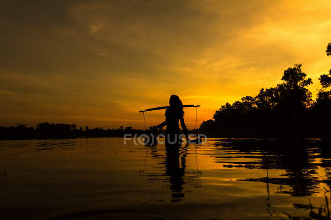 Mulher coletando água ao nascer do sol, reservatório Srah Srang, Complexo Angkor Wat, Siem Reap, Camboja — Fotografia de Stock