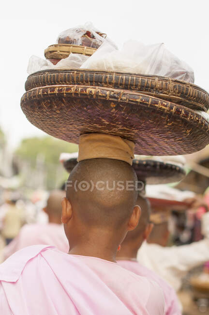 Jeunes moines bouddhistes portant des paniers sur la tête, Bagan, Myanmar — Photo de stock